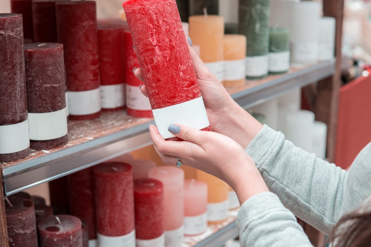 Closeup view of woman hands choosing festive decorative candles for Christmas or New Year celebration